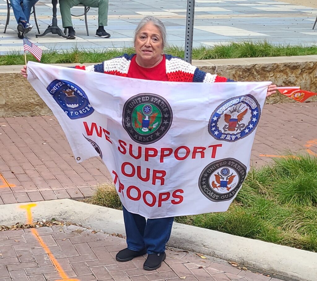 woman holding a banner in support of the troops